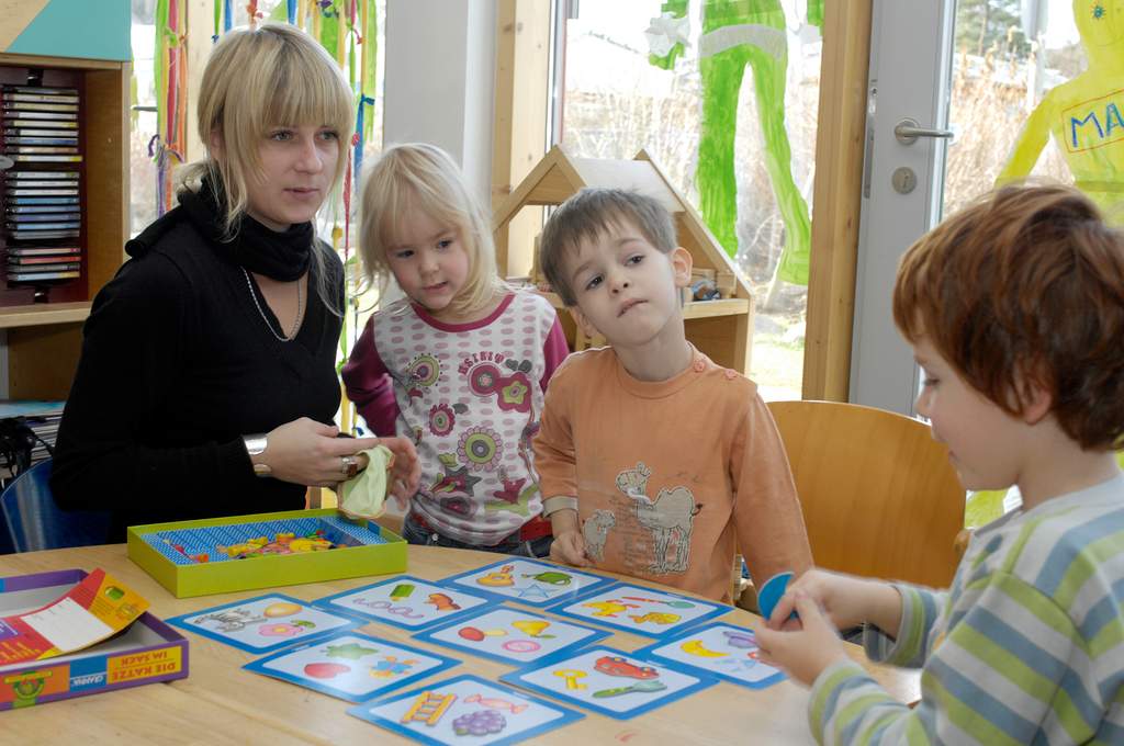 17 SERVICE_Schule_Frühpädagogik_Erzieherin Kinder spielen mit einer Frau