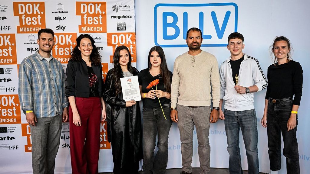 DOK.fest 2025 Preisverleihung: Mathis Welker (Juror & BLLV), Maya Reichert (Leitung DOK.education), Preisträgerin Miray Erbolat mit ihrem Filmteam und den Filmlehrkräften Serkan Erol (5. v.l.) und Susanne Starman (r.)