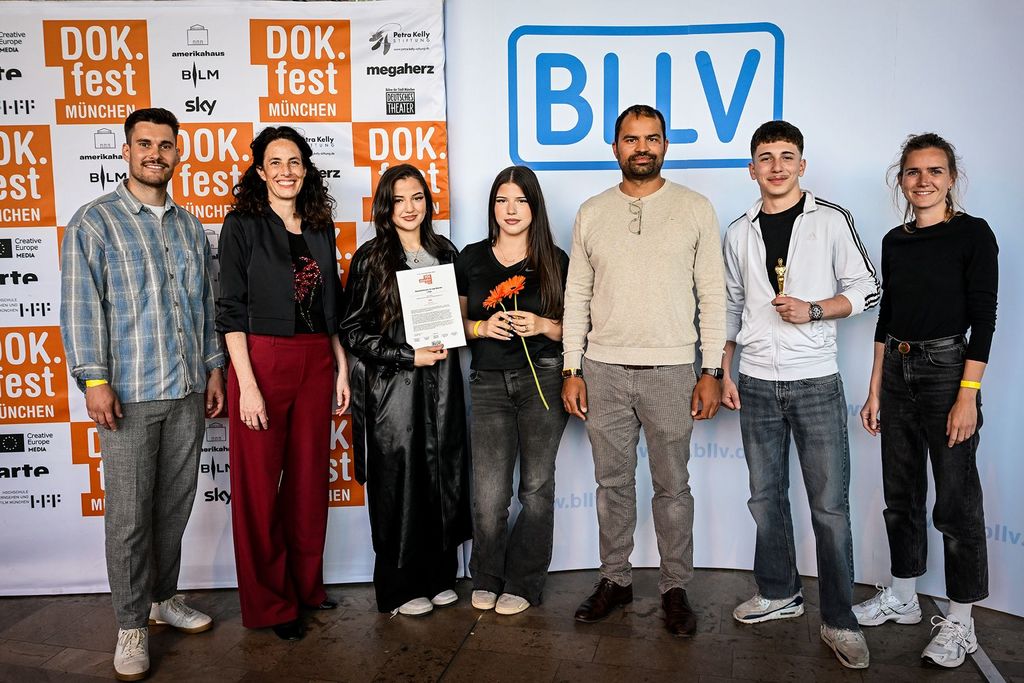 DOK.fest 2025 Preisverleihung: Mathis Welker (Juror & BLLV), Maya Reichert (Leitung DOK.education), Preisträgerin Miray Erbolat mit ihrem Filmteam und den Filmlehrkräften Serkan Erol (5. v.l.) und Susanne Starman (r.)