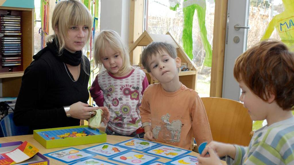 Kinder spielen mit einer Frau